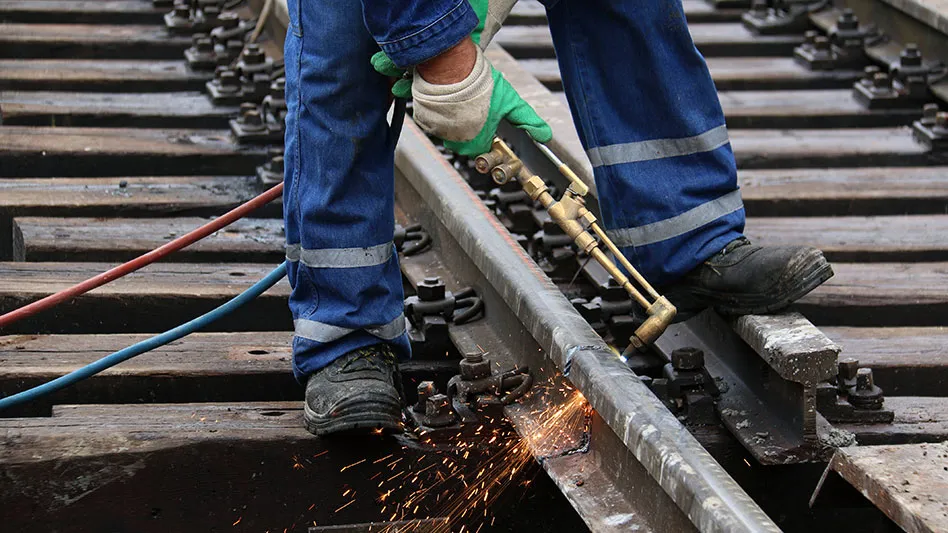 laborer repairs rail line